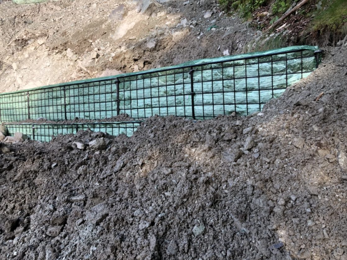 Ｏ村治山工事 コルゲート据え付けカゴ枠床掘り、据付、石積み一部 三島建設株式会社